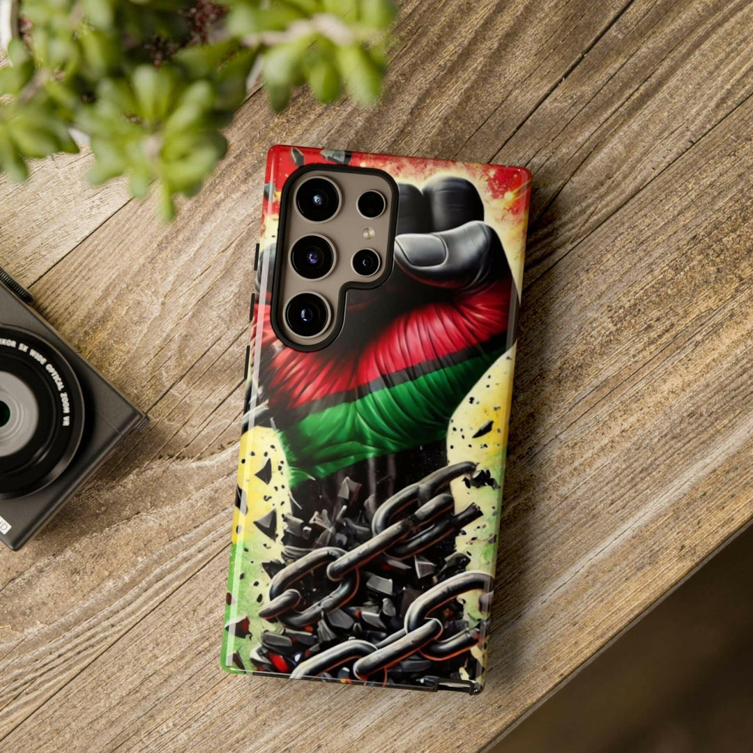 Black Pan-African fist phone case with chains breaking free, symbolizing strength and liberation. Durable and stylish for cultural expression.