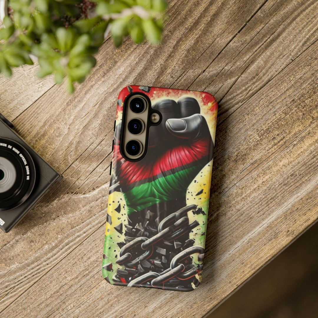 Black Pan-African fist phone case with chains breaking free, symbolizing strength and liberation. Durable and stylish for cultural expression.