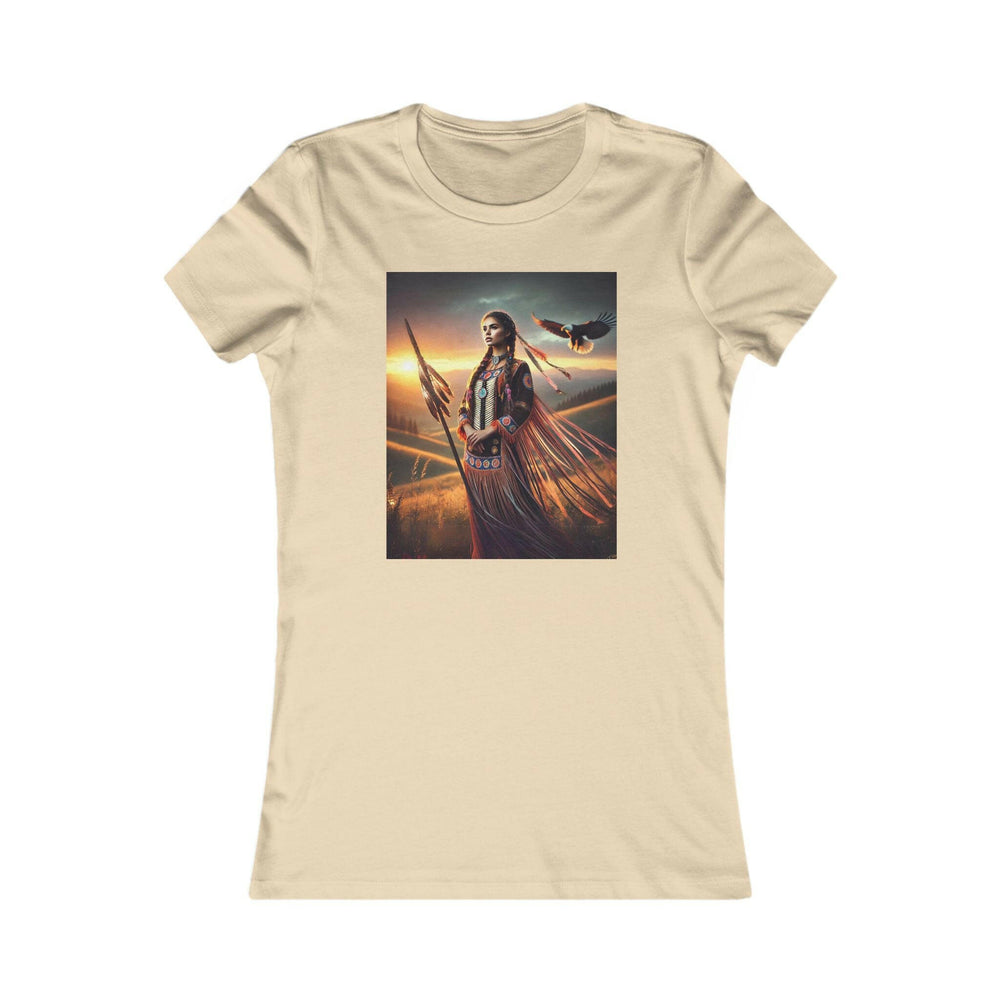 Soft Cream T-shirt featuring an illustration of a Native American warrior woman with a spear, set against a dramatic sunset. Represents strength, heritage, and cultural pride.