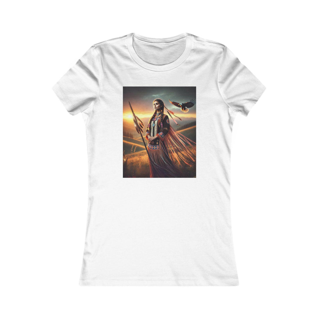 White T-shirt featuring an illustration of a Native American warrior woman with a spear, set against a dramatic sunset. Represents strength, heritage, and cultural pride.