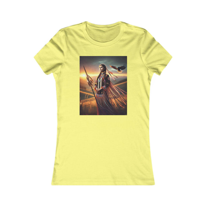 Yellow T-shirt featuring an illustration of a Native American warrior woman with a spear, set against a dramatic sunset. Represents strength, heritage, and cultural pride.