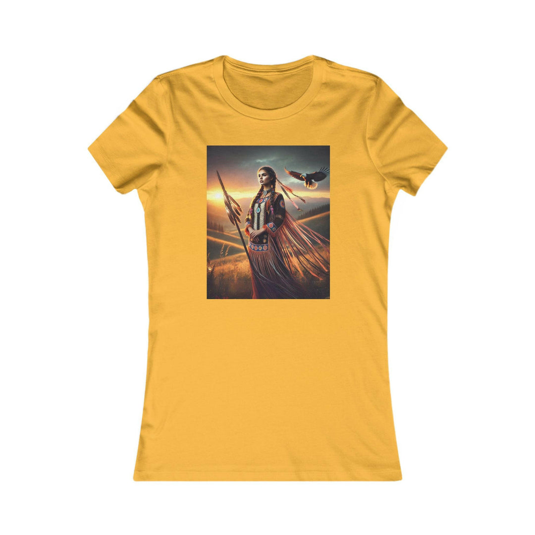 Gold T-shirt featuring an illustration of a Native American warrior woman with a spear, set against a dramatic sunset. Represents strength, heritage, and cultural pride.